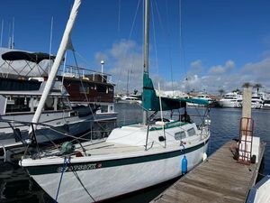 Jensen Cal 29 1973 Jensen Cal 29 sailboat docked at marina under clear blue sky.