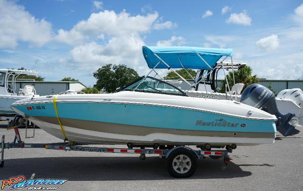 NauticStar 203DC Sport Deck 2018 NauticStar 203DC Sport Deck boat on a trailer with blue canopy.