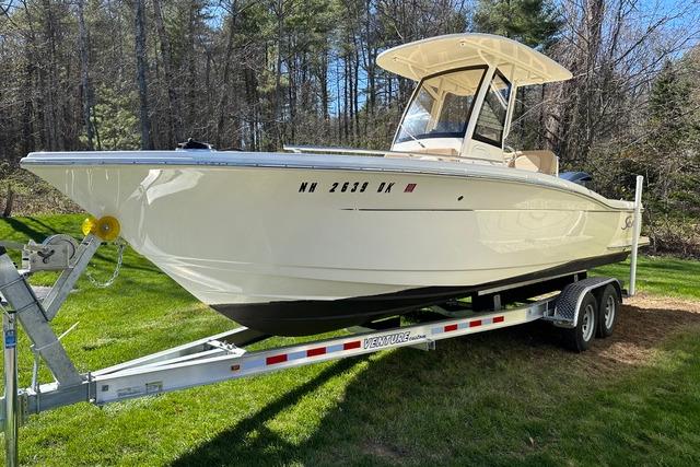 Scout 235 XSF 2021 Scout 235 XSF boat on trailer, parked on grass with forest background.