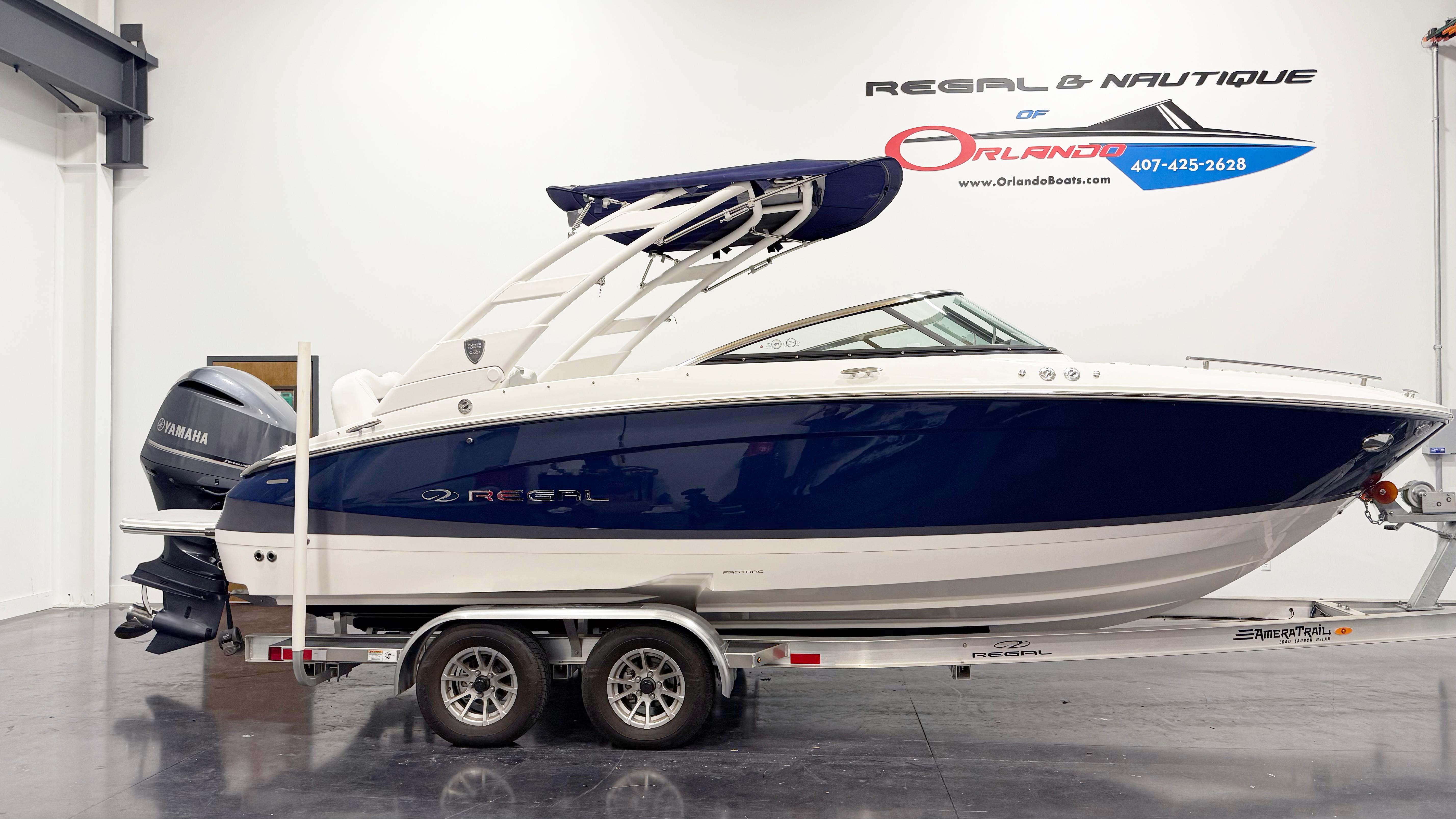 Regal LX4 2025 Regal LX4 boat on trailer in showroom, featuring sleek design and Yamaha engine.