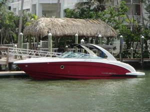 Regal 3200 Bowrider 2017 Regal 3200 Bowrider boat docked by tropical waterfront.