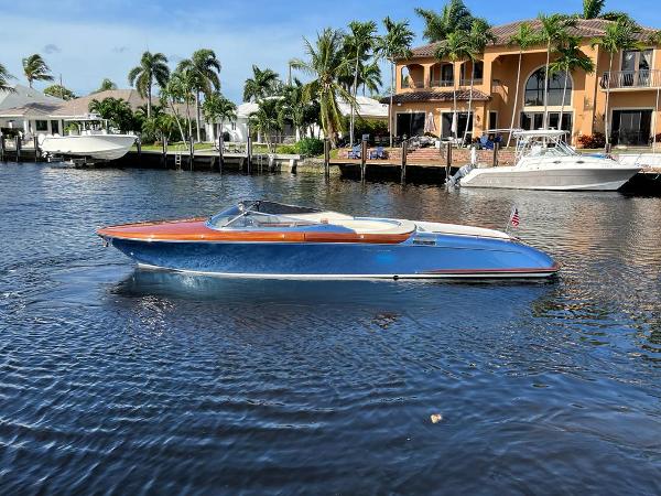 Riva Aquariva Super 2012 Riva Aquariva Super boat cruising on a sunny waterfront with luxury homes.