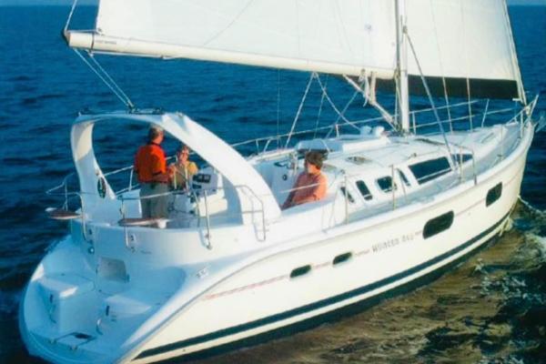Hunter 410 Sailing yacht Hunter 410, 1999 model, cruising on open sea with passengers on deck.
