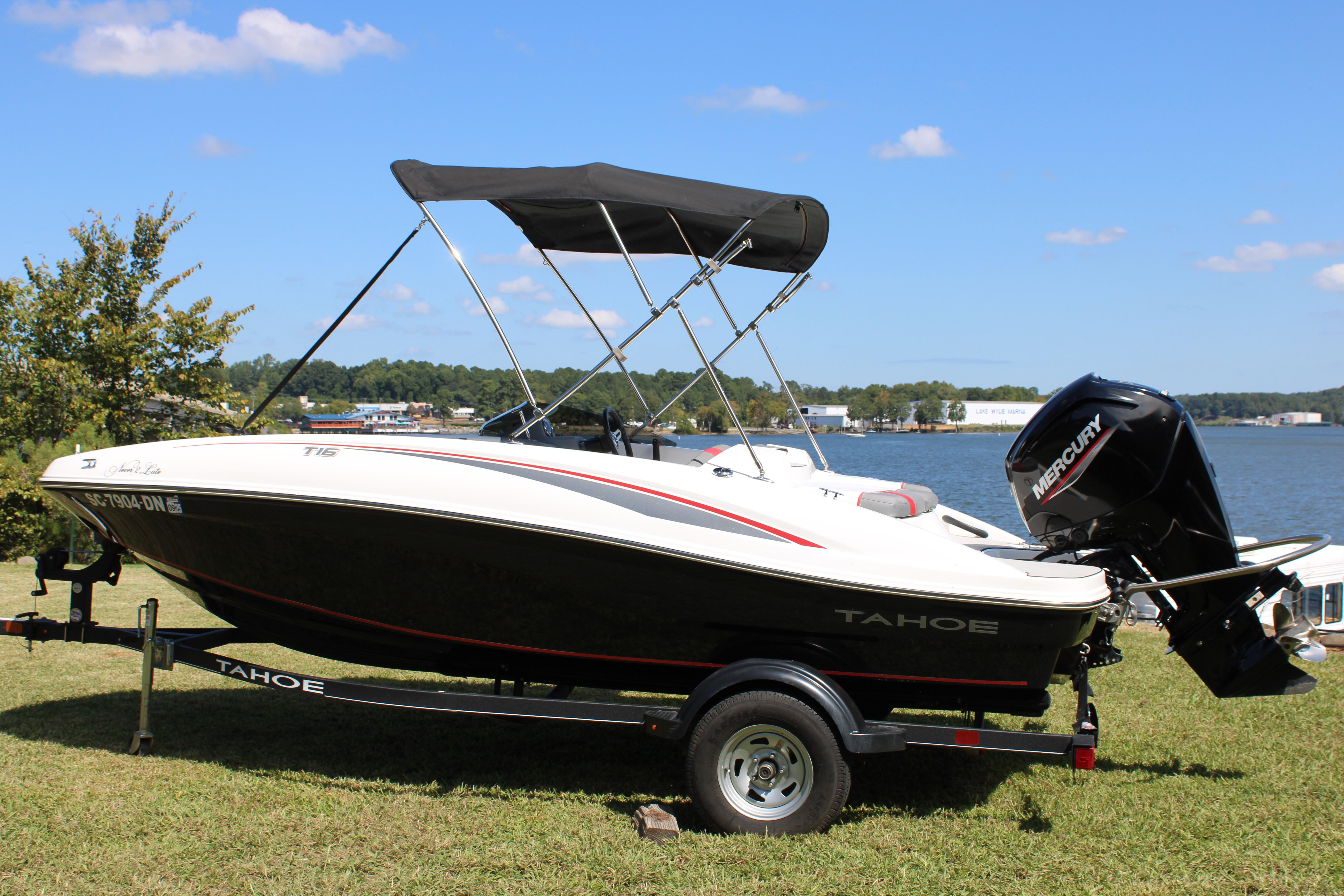 Tahoe T16 2021 Tahoe T16 boat with Mercury engine on trailer by a lake.