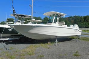 Boston Whaler 280 Dauntless 2023 Boston Whaler 280 Dauntless boat on display, elevated on stands, with clear blue sky.