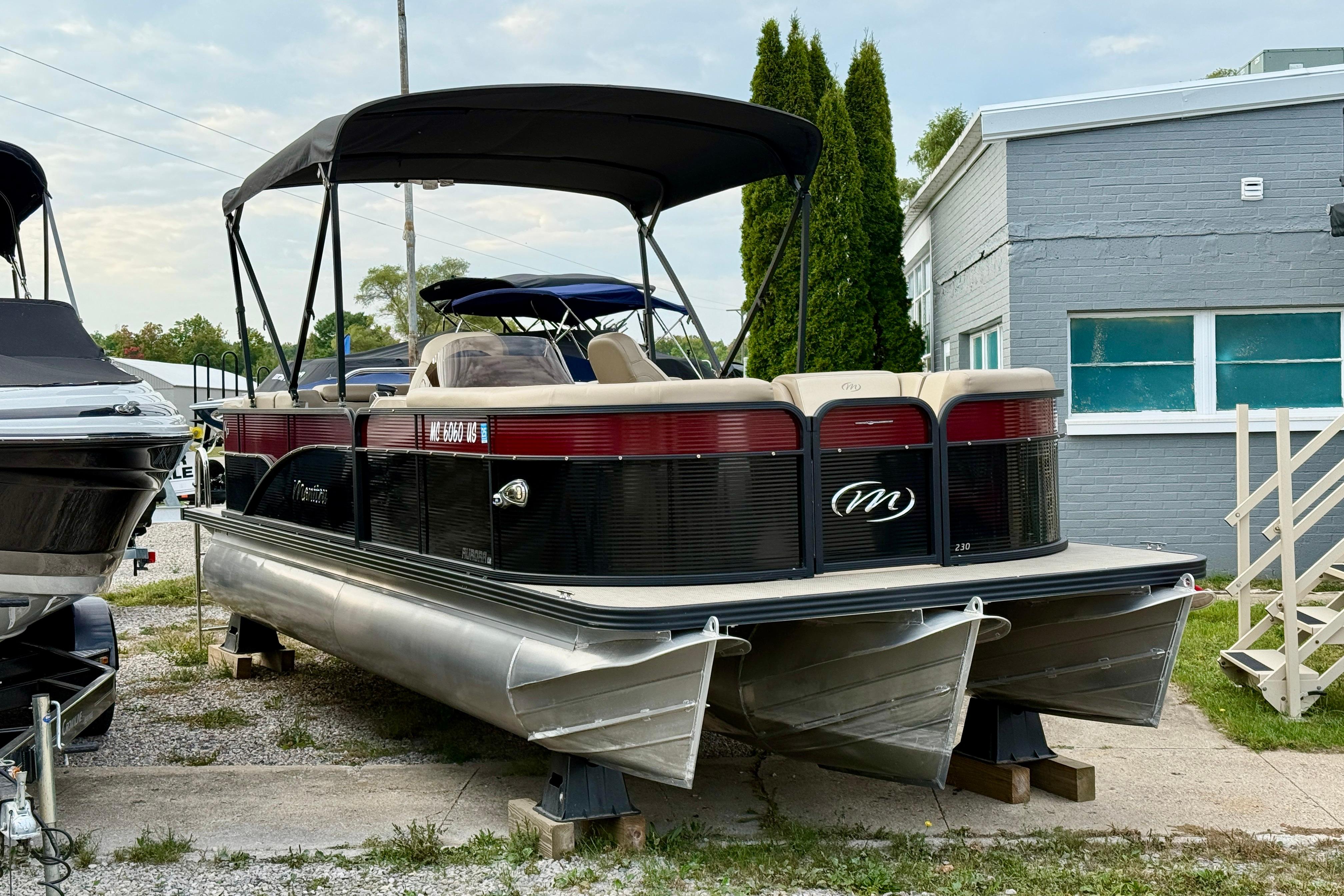 Manitou Aurora LE VP 2022 Manitou Aurora LE VP pontoon boat with canopy, parked outdoors.
