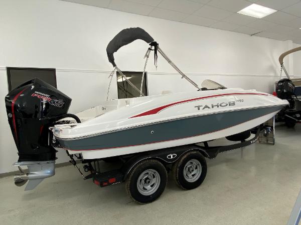 Tahoe 1950 2024 Tahoe 1950 boat with outboard motor on a trailer in showroom.
