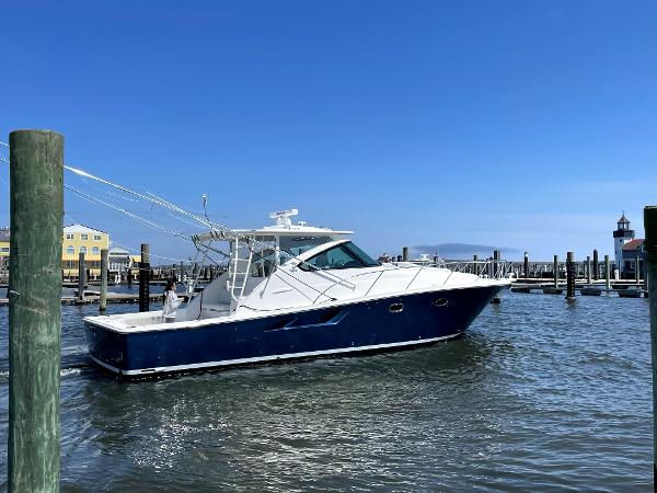 Tiara Yachts 43 Open 2023 Tiara Yachts 43 Open cruising in a marina under clear blue skies.