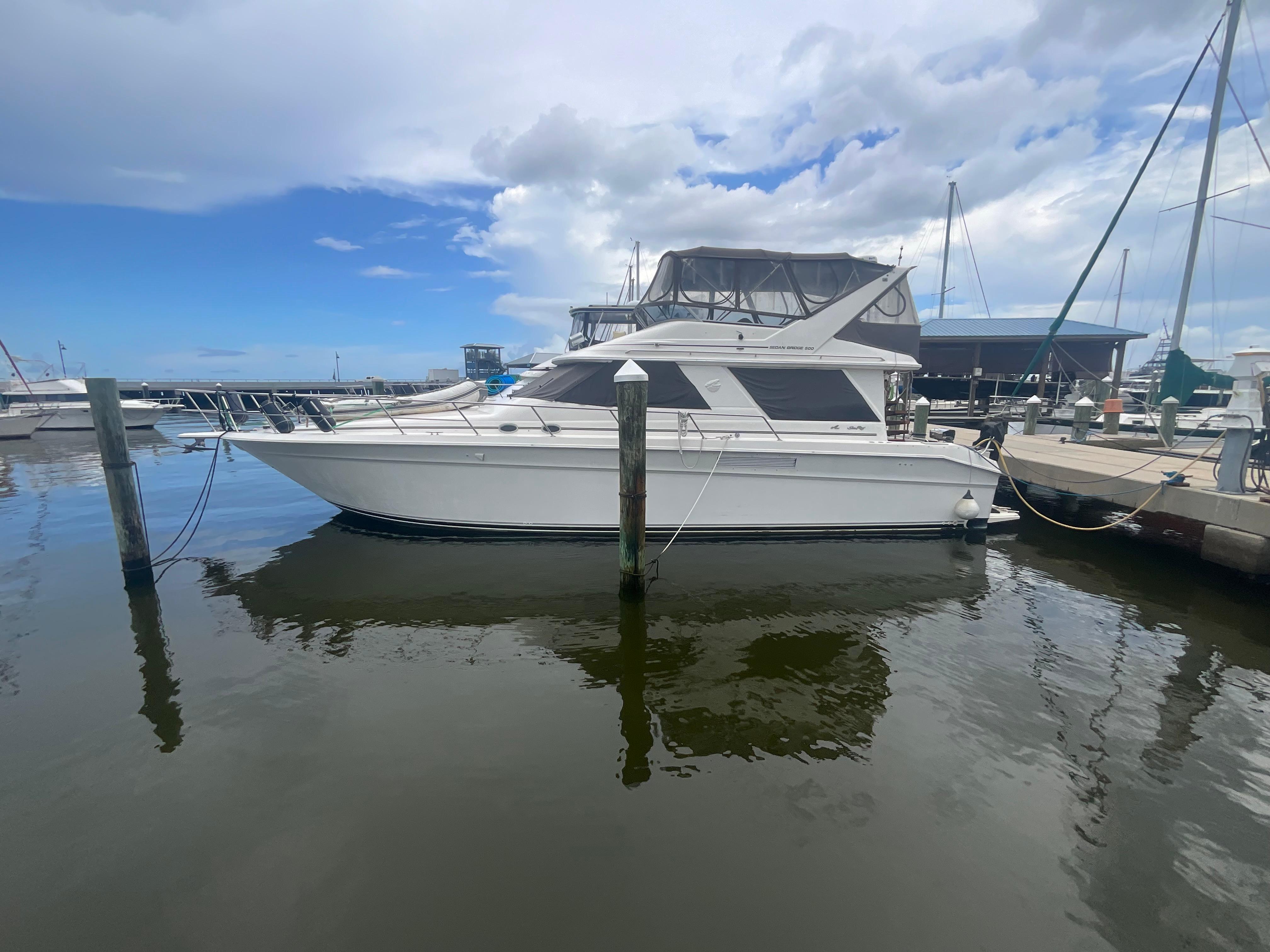Sea Ray Sedan Bridge 1991 Sea Ray Sedan Bridge yacht docked at marina under cloudy sky.