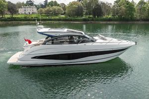 Princess V50 2025 Princess V50 yacht cruising on a serene lake with lush greenery in the background.