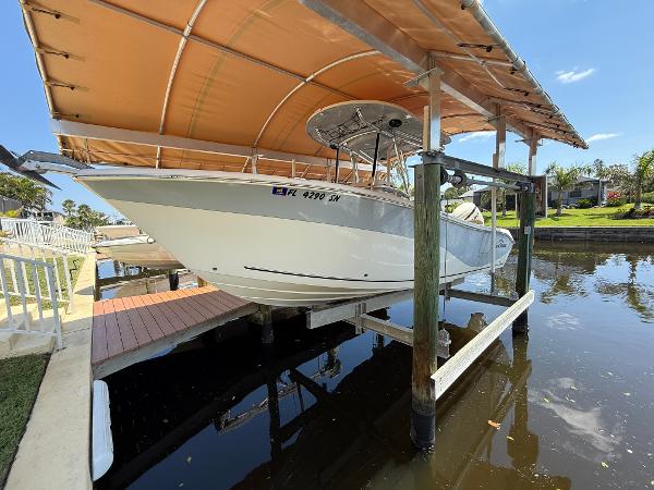 Sea Chaser 24 HFC 2020 Sea Chaser 24 HFC boat docked under canopy on calm water.