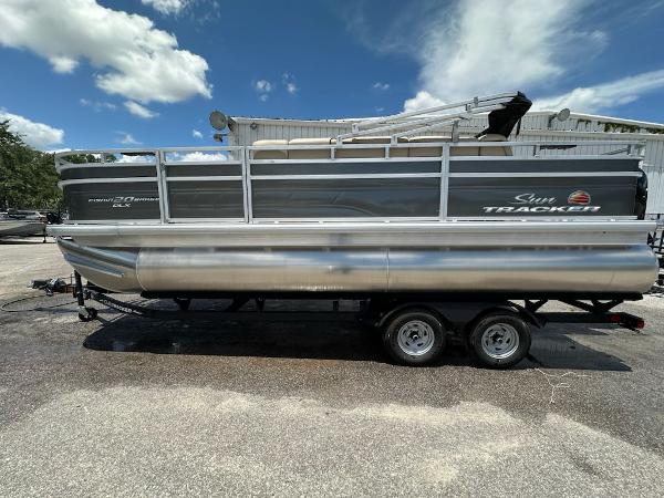 Sun Tracker Fishin' Barge 20 DLX 2025 Sun Tracker Fishin' Barge 20 DLX pontoon boat on trailer under blue sky.