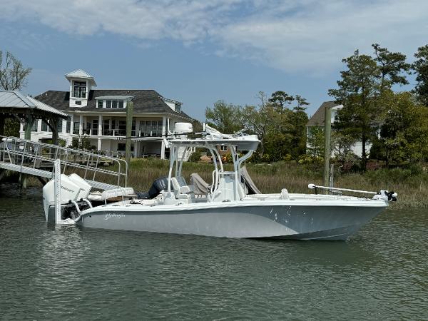Yellowfin 26 Hybrid 2025 Yellowfin 26 Hybrid boat docked near a waterfront house.