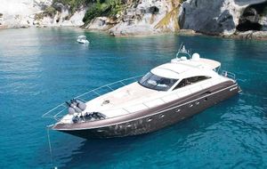 Princess V65 Luxurious 2002 Princess V65 yacht anchored in clear turquoise waters near rocky cliffs.