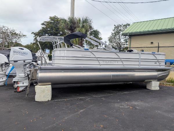 Trifecta 24 RF LE 2025 Trifecta 24 RF LE pontoon boat with Suzuki outboard motor on display.