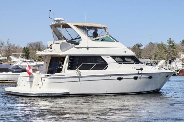 Carver 460 Voyager 2004 Carver 460 Voyager yacht cruising on a calm lake.