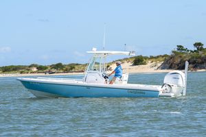 Everglades 243 Center Console 2016 Everglades 243 Center Console boat cruising on water near sandy shoreline.