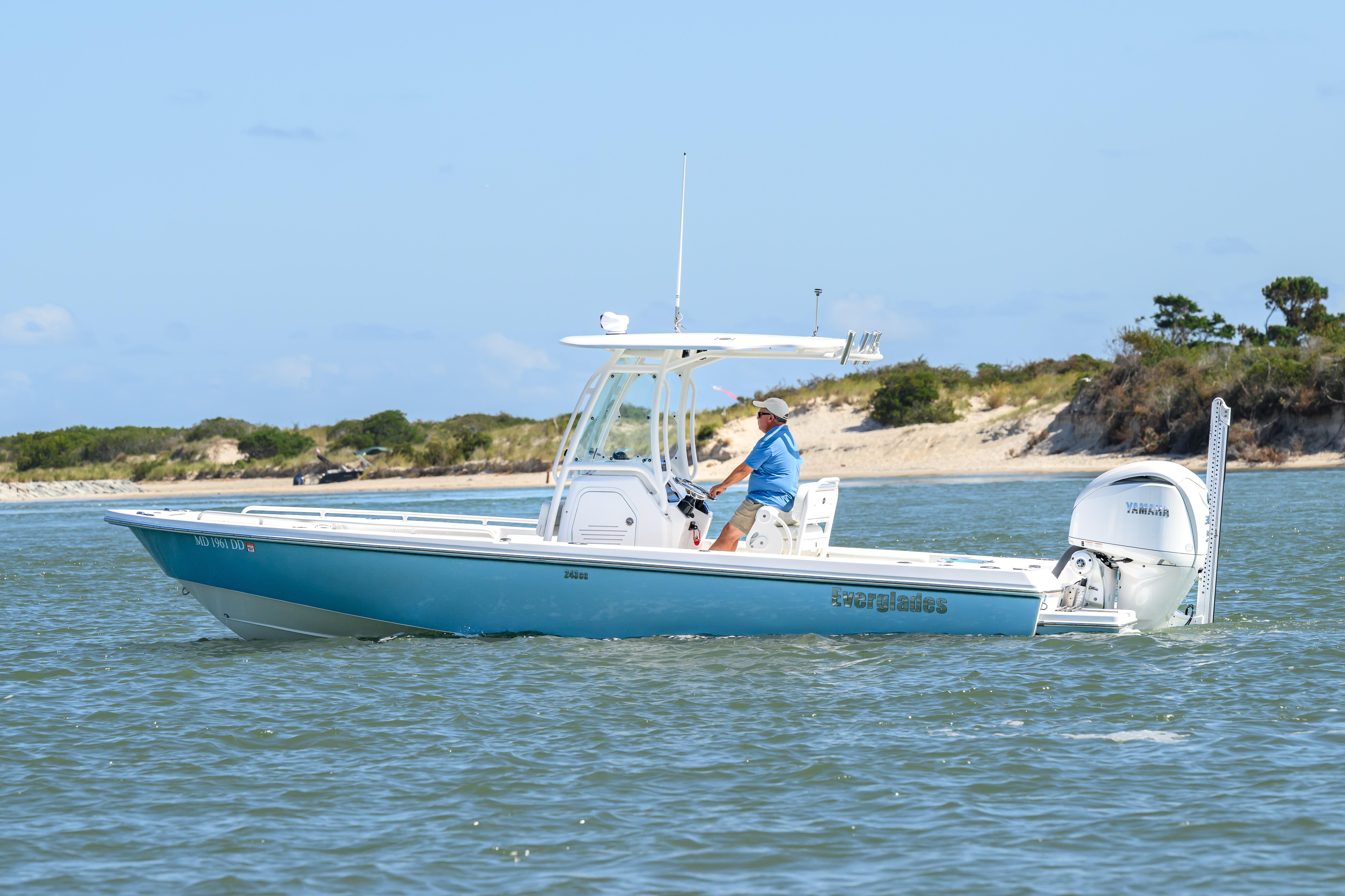 Everglades 243 Center Console 2016 Everglades 243 Center Console boat cruising on water near sandy shoreline.