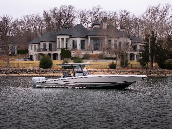 Fountain 38 SC 2022 Fountain 38 SC boat cruising on a lake with a luxury house in the background.