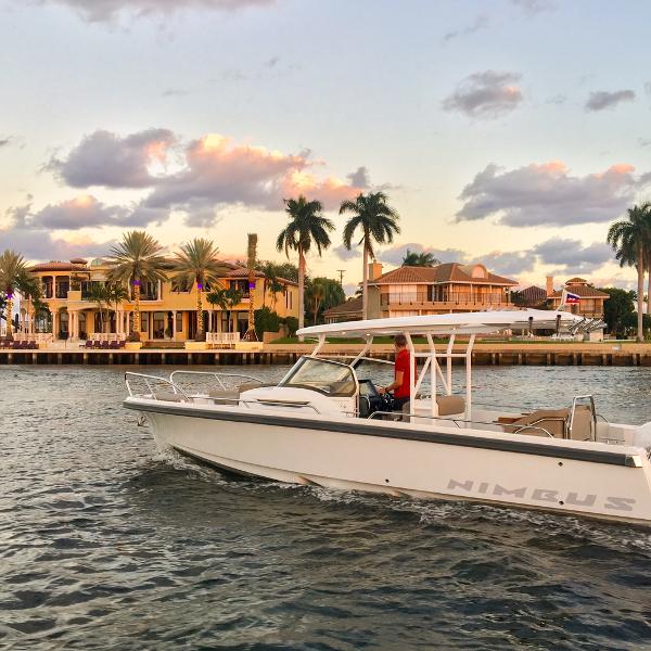 Nimbus Tender 9 2024 Nimbus Tender 9 boat cruising near luxury waterfront homes at sunset.