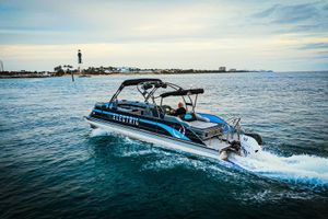 Vision Marine Technologies V30 Electric Vision Marine Technologies V30 boat cruising near a lighthouse, 2025 model.