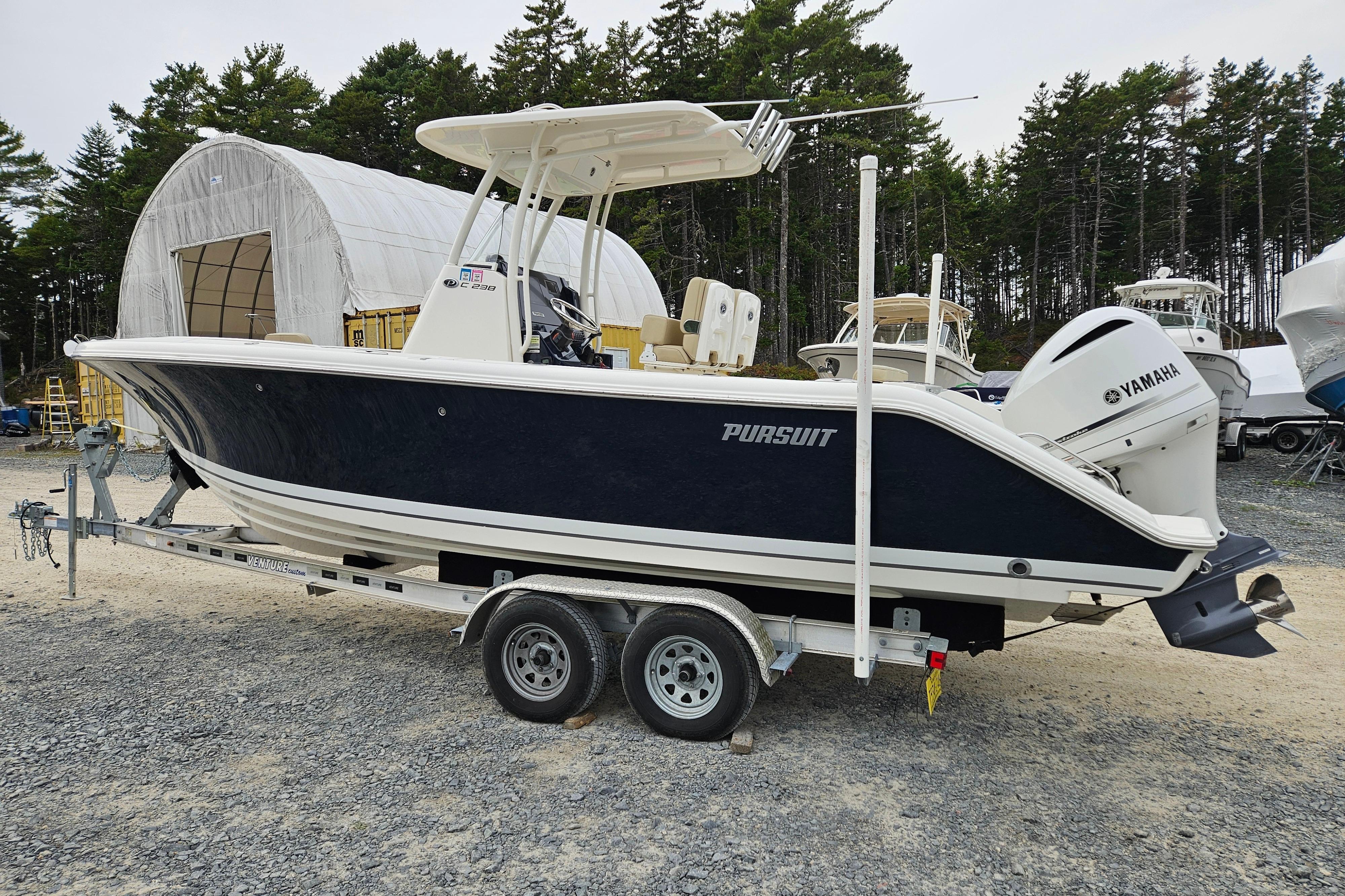 Pursuit C 238 Center Console 2020 Pursuit C 238 Center Console boat on trailer, parked outdoors.