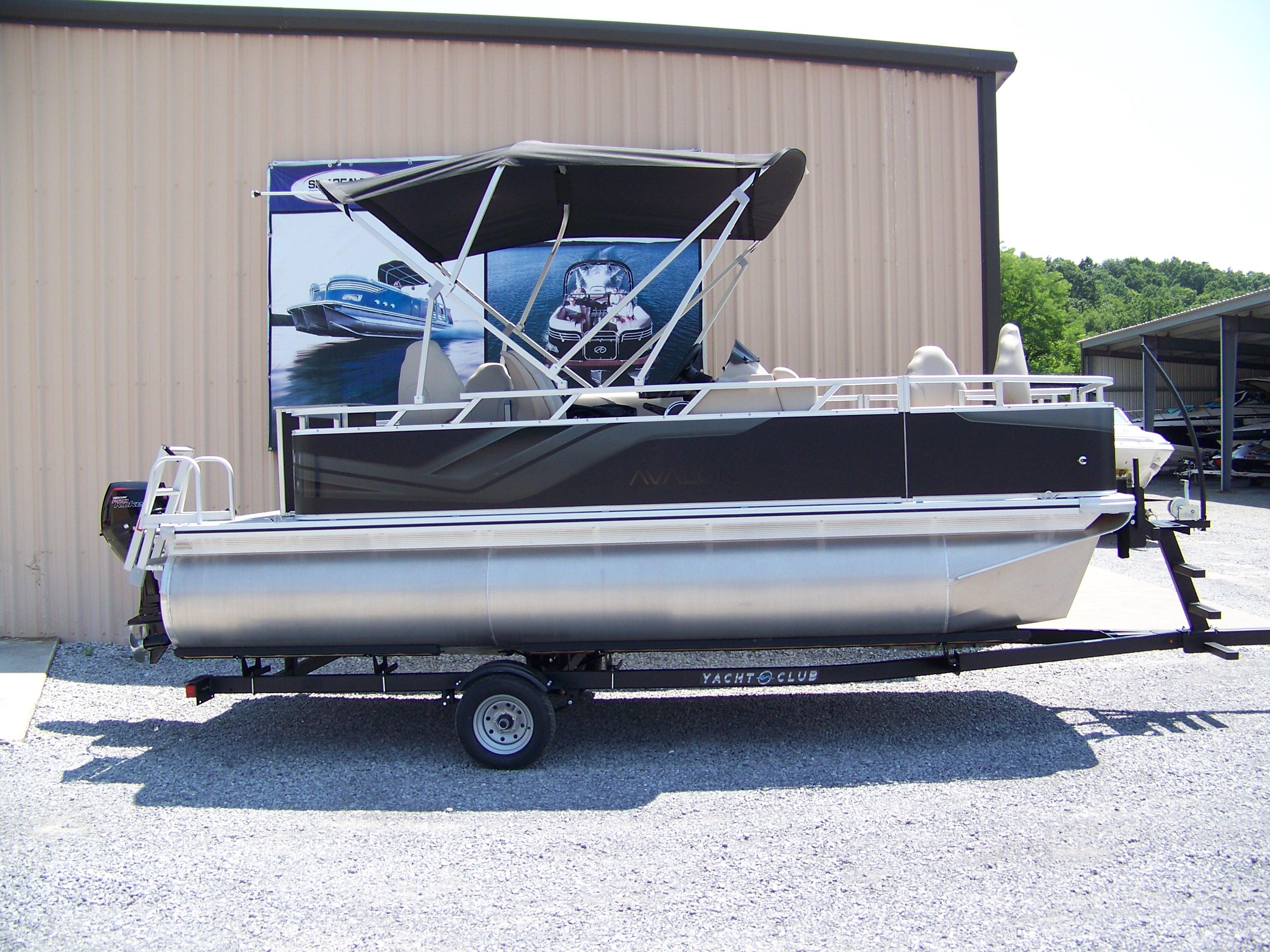 Avalon VTX Quad Fish 2025 Avalon VTX Quad Fish pontoon boat on trailer, parked outside a building.