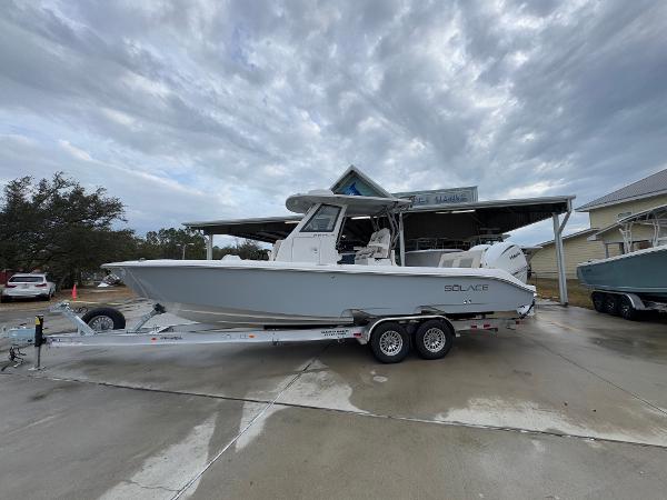 Solace 28 HCS 2025 Solace 28 HCS boat on trailer, parked outdoors under cloudy sky.