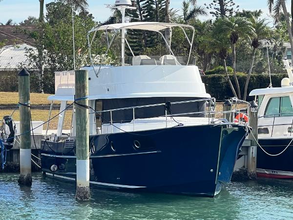 Beneteau Swift Trawler 44 2019 Beneteau Swift Trawler 44 docked in a marina, surrounded by lush greenery.