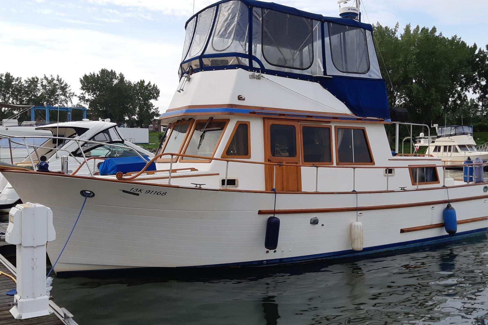 CHB Oceania 1981 CHB Trawler Oceania docked, featuring classic design and blue canopy.