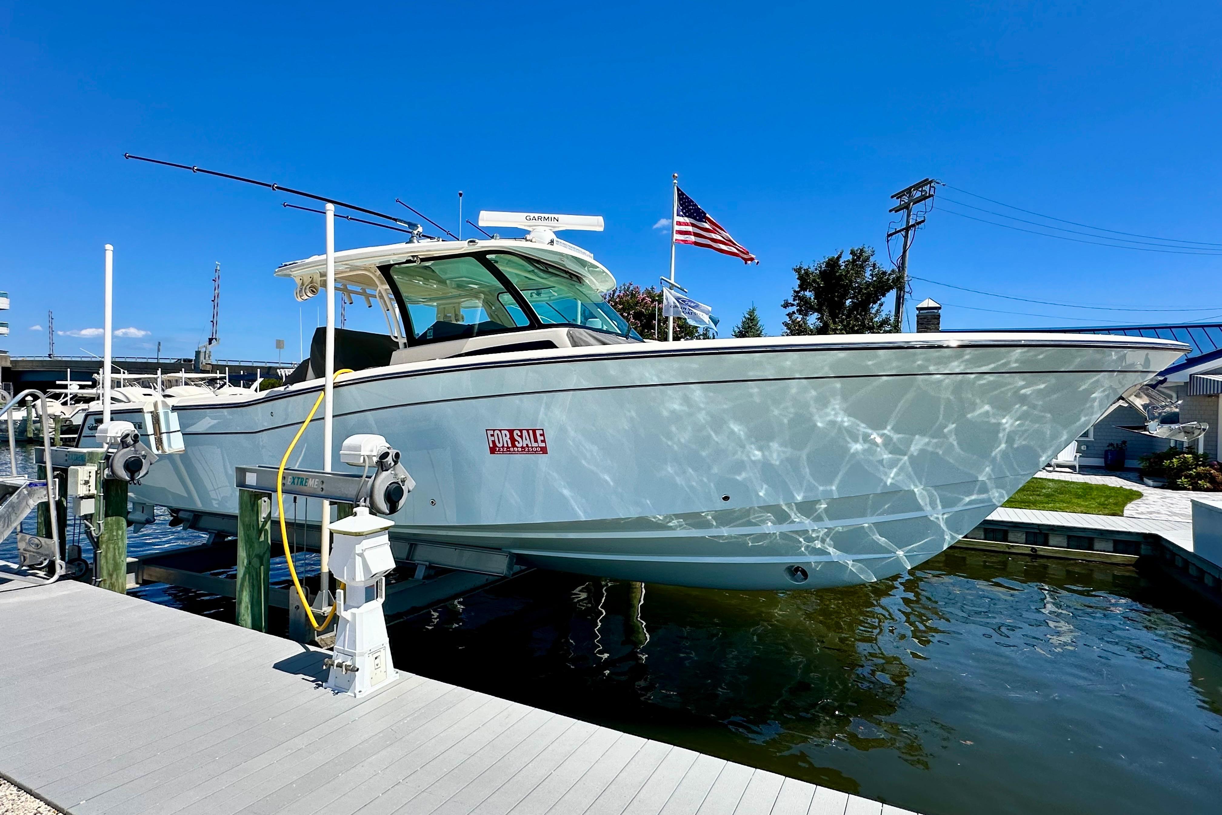 Grady-White Canyon 386 2025 Grady-White Canyon 386 boat for sale, docked with American flag, clear blue sky.