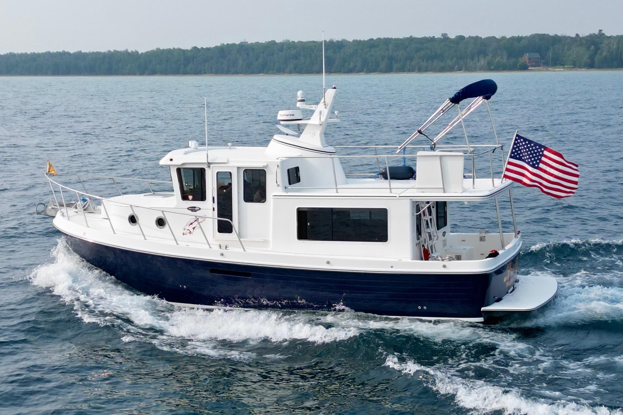 American Tug 365 2018 American Tug 365 cruising on open water with American flag.