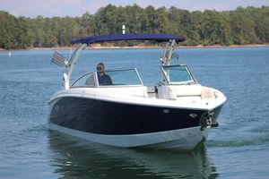 Cobalt R7 Surf 2020 Cobalt R7 Surf boat cruising on a serene lake with forested shoreline.