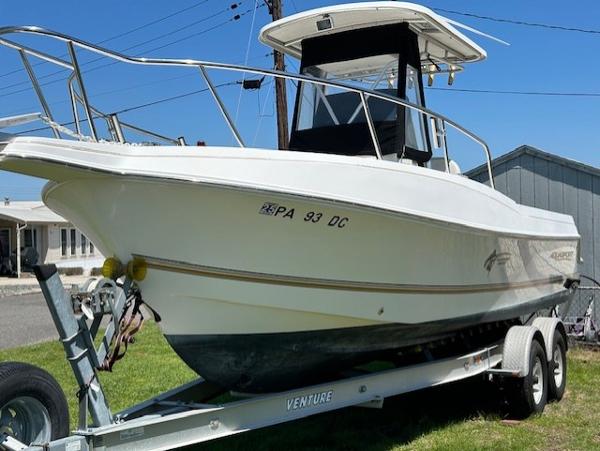 Aquasport 250 Osprey 2003 Aquasport 250 Osprey boat on trailer, parked outdoors.
