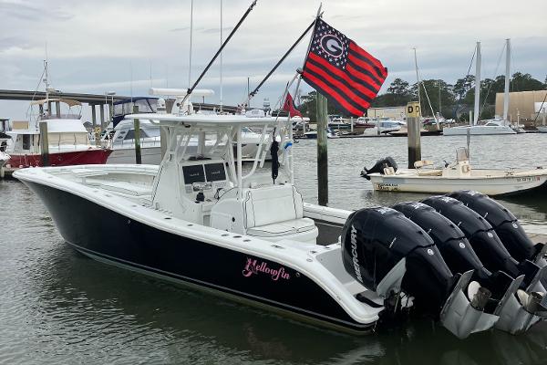 Yellowfin 36 2007 Yellowfin 36 boat docked, featuring four outboard engines and a distinctive flag.