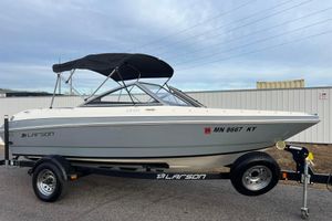 Larson LX 205S IO 2013 Larson LX 205S IO boat on trailer with canopy, parked outdoors.