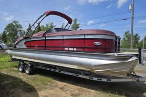 Manitou Legacy 25 RFXW 2019 Manitou Legacy 25 RFXW pontoon boat on trailer, red and silver design, parked outdoors.