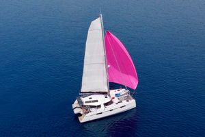 Nautitech 40 Open 2017 Nautitech 40 Open catamaran sailing with pink spinnaker on blue ocean.
