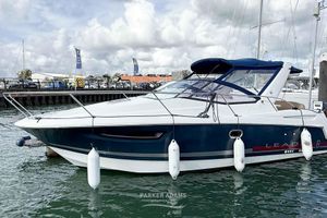 Jeanneau Leader 8 2014 Jeanneau Leader 8 boat docked in marina, featuring sleek design and blue canopy.