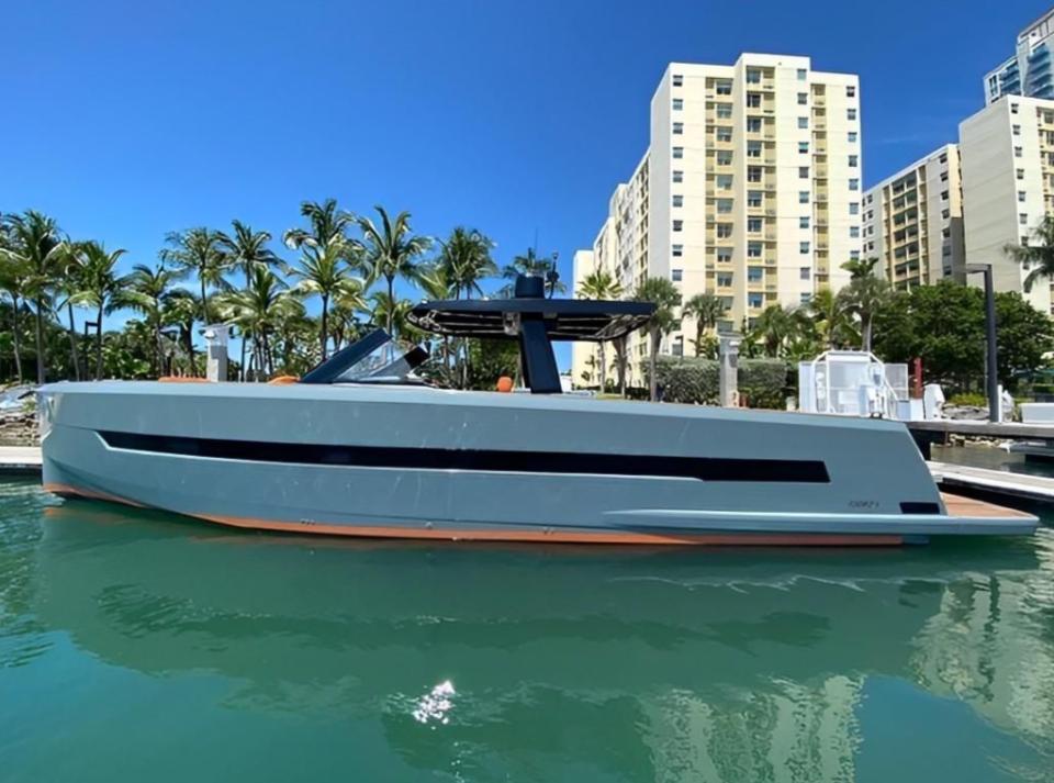 Fjord 52 Open 2019 Fjord 52 Open yacht docked, with palm trees and buildings in the background.