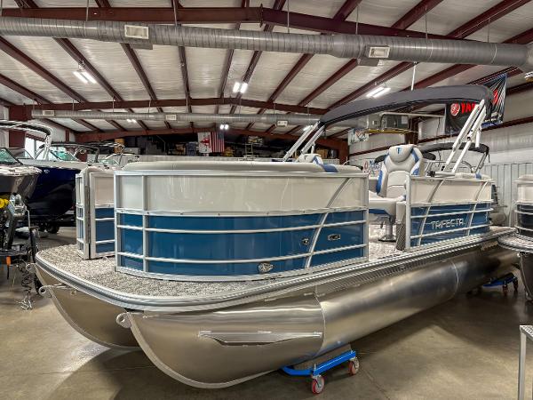 Trifecta 20RF LE 2025 Trifecta 20RF LE pontoon boat in showroom, featuring sleek blue and silver design.