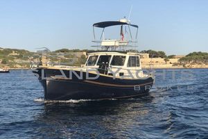 Menorquin 120 VENDIDO 2006 Menorquin 120 Fly yacht on calm waters with scenic coastal background.