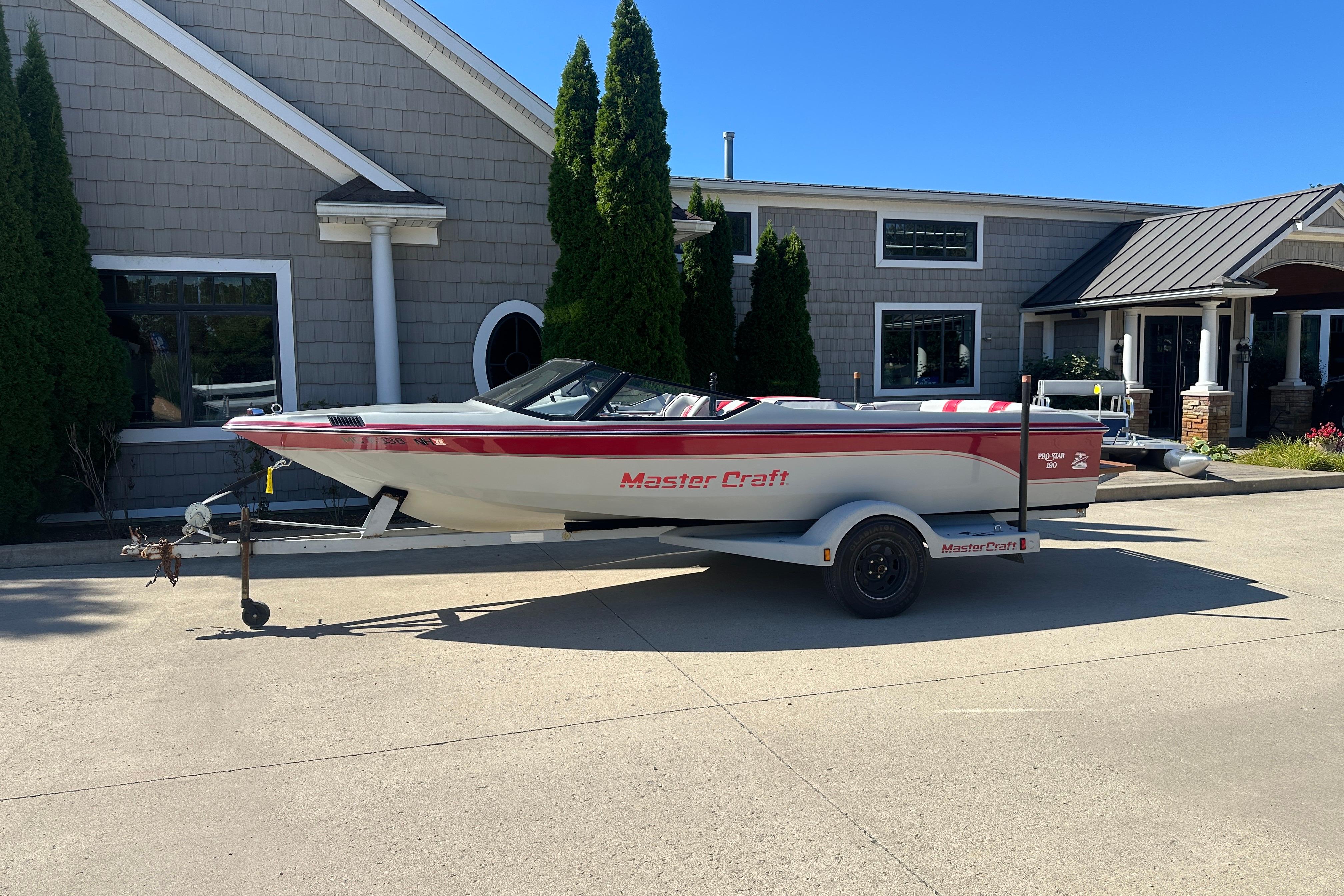 MasterCraft ProStar 190 1987 MasterCraft ProStar 190 boat on trailer, parked outside a building.