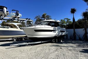 Jeanneau NC 895 2019 Jeanneau NC 895 boat on trailer, parked outdoors under clear blue sky.