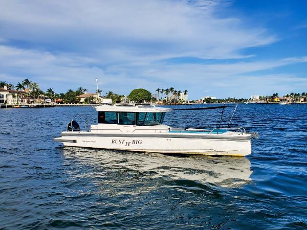 Axopar 28 CABIN 2021 Axopar 28 CABIN boat on a sunny waterfront.