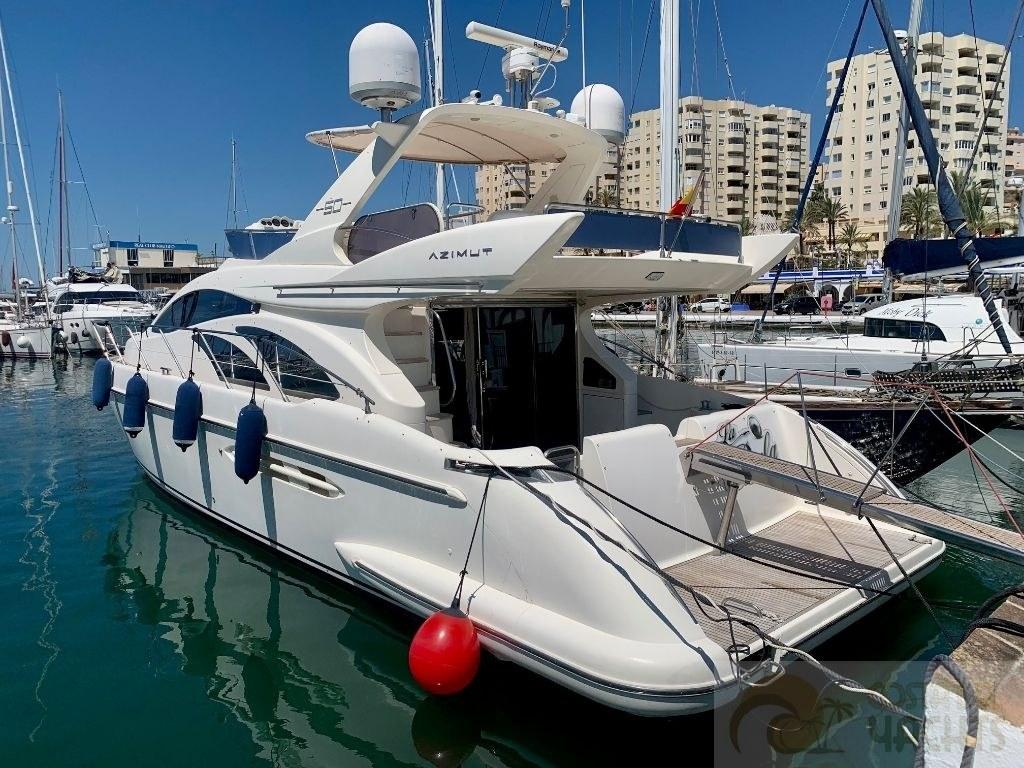 Azimut 50 fly Azimut 50 Fly 2006 yacht docked in marina, surrounded by other boats and buildings.
