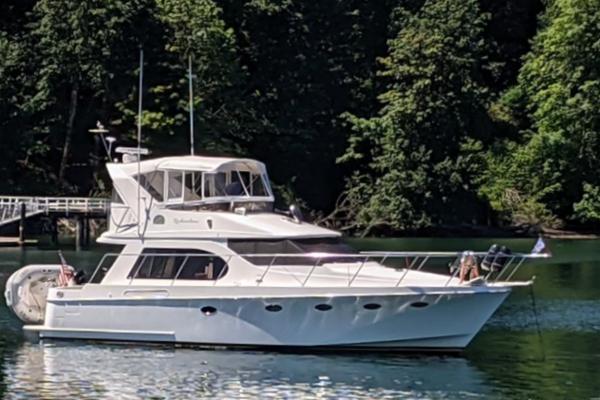 Ocean Alexander 42 Altus 2005 Ocean Alexander 42 Altus yacht on serene water with lush forest backdrop.