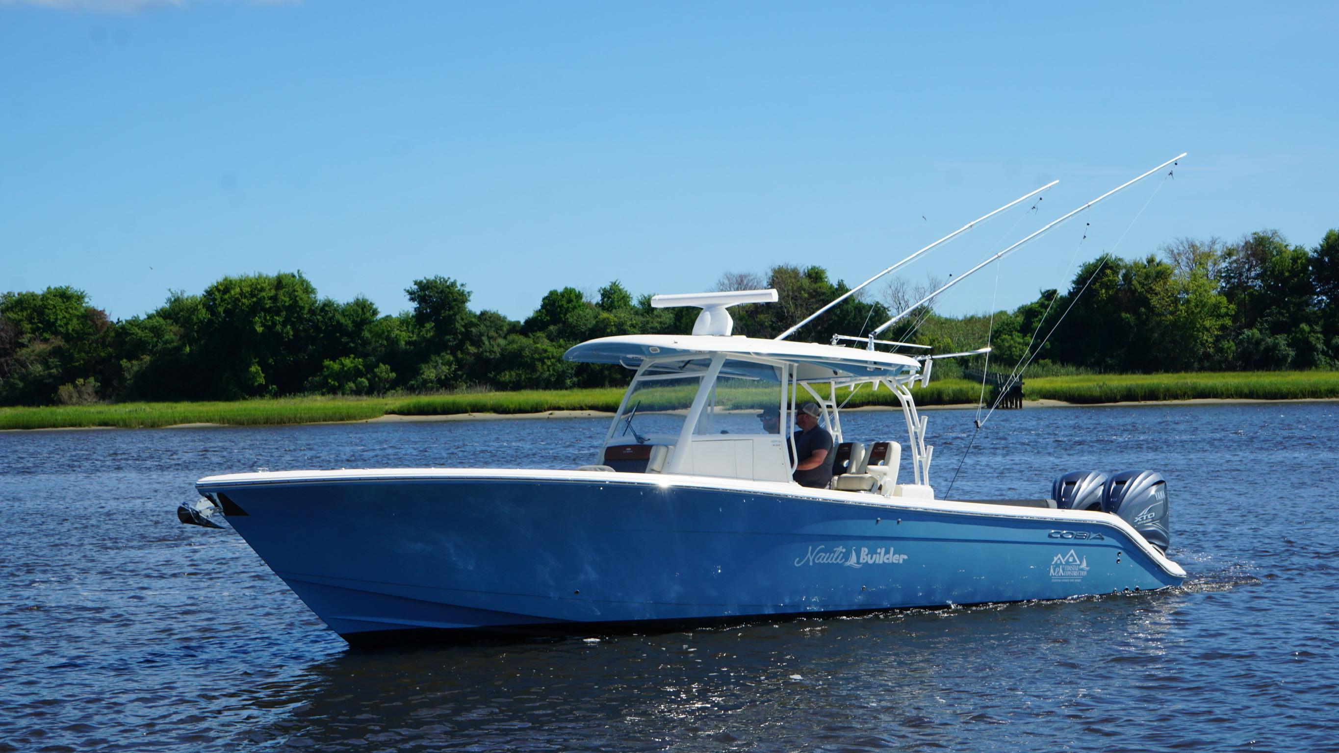 Cobia 350 Center Console 2022 Cobia 350 Center Console boat on calm water, surrounded by lush greenery.