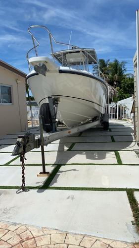 Boston Whaler 26 Outrage 2001 Boston Whaler Outrage 26 CC boat on trailer, parked outdoors under clear sky.