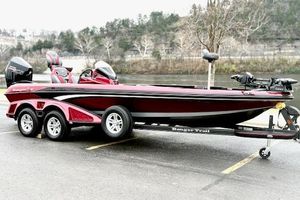Ranger Z521R Cup-Equipped 2025 Ranger Z521R Cup-Equipped boat, red and black, parked on a trailer by a river.